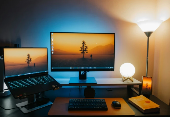 A computer desk with two monitors and a keyboard